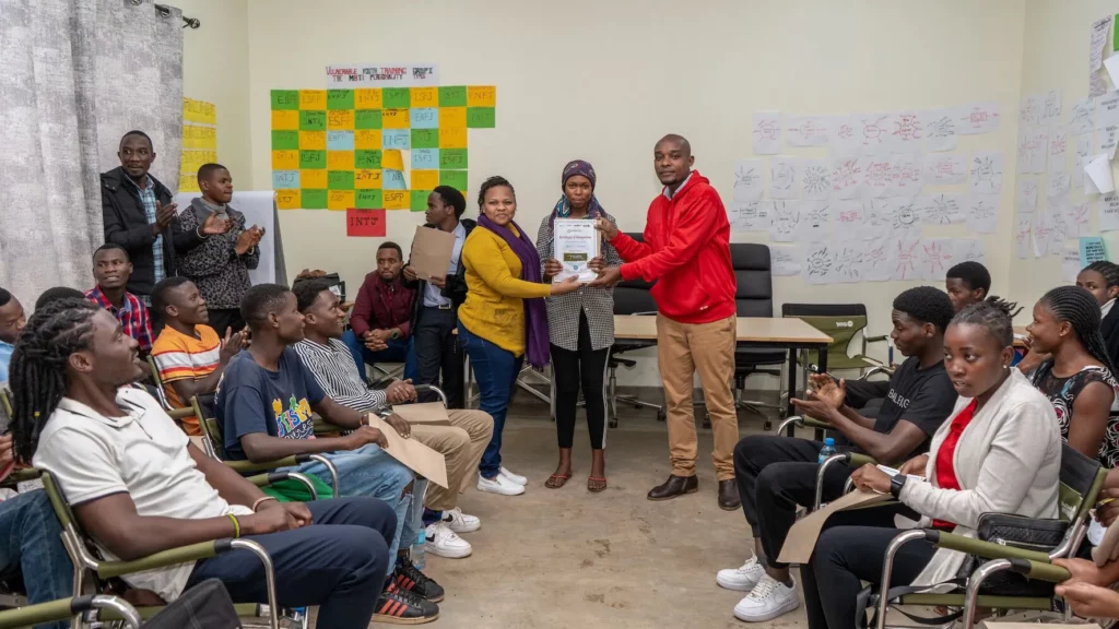 Salle de classe avec une étudiante tanzanienne tenant un diplôme