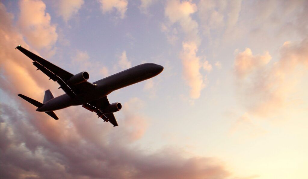 Avion vu de dessous devant les nuages